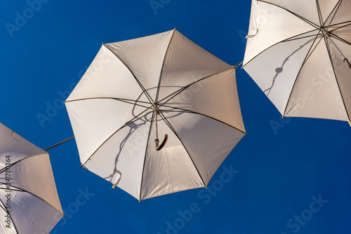 White umbrellas on a clear blue sky