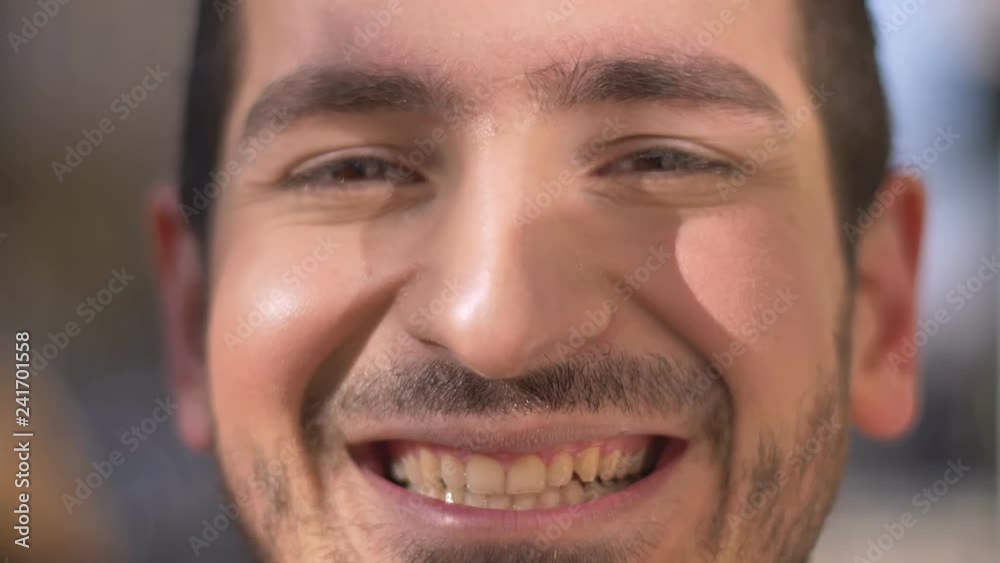 Close-up portrait of young caucasian man laughing sincerely into camera on blurred background. Close-up portrait of young caucasian man laughing sincerely into camera on blurred background.