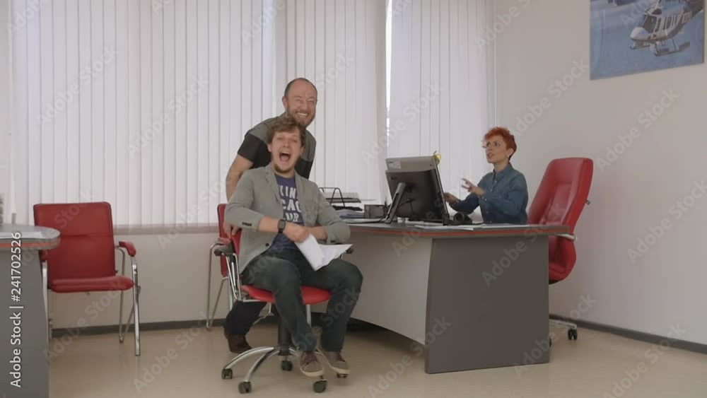 Office chair race. Slow motion. Young guys have fun in the office during a break. Games from large offices. Woman boss in shock, the staff dismissed. The revolt at the chief office. Party office. Office chair race. Slow motion. Young guys have fun in the office during a break. Games from large offices. Woman boss in shock, the staff dismissed. The revolt at the chief office. Party office.