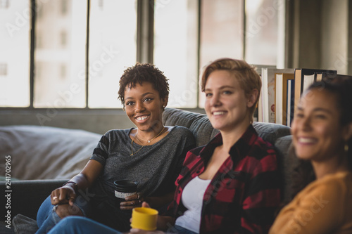 Young adult friends socialising in a loft apartment photo