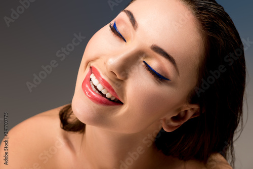 portrait of beautiful smiling woman with glamorous makeup and eyes closed