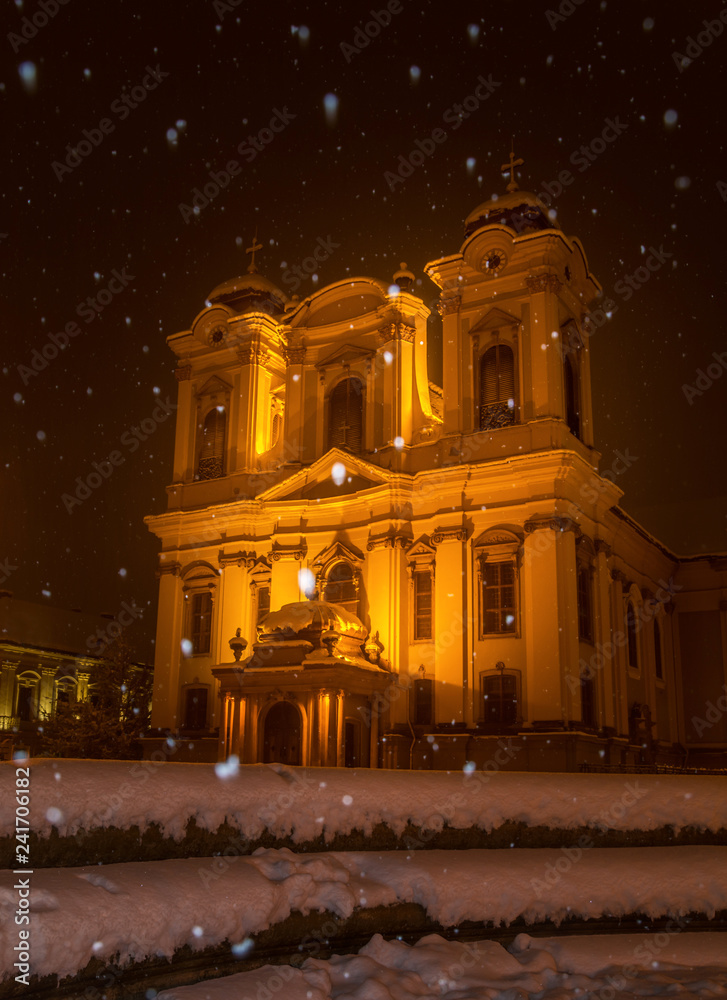 Church at night when snowing. Catholic church during a heavy nighttime snowfall on Christmas. Winter, snow, snowfall, snowflakes, church, lights.