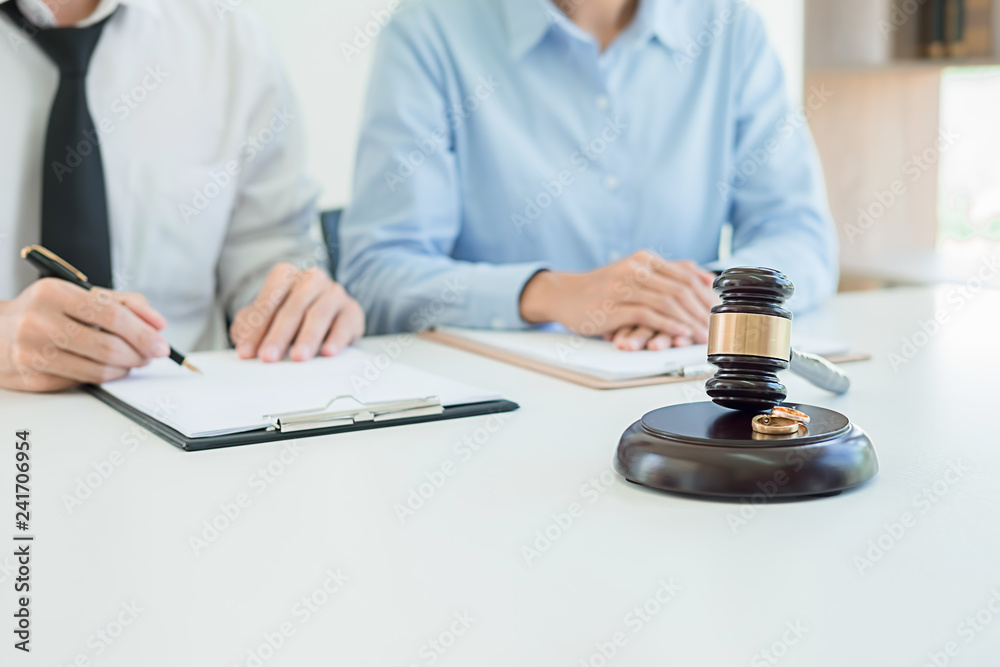 Judge gavel with Justice lawyers deciding, consultation on marriage divorce between married couple and signing divorce documents on table. Concepts of Law and Legal sevices. Judge gavel with Justice lawyers deciding, consultation on marriage divorce between married couple and signing divorce documents on table. Concepts of Law and Legal sevices.