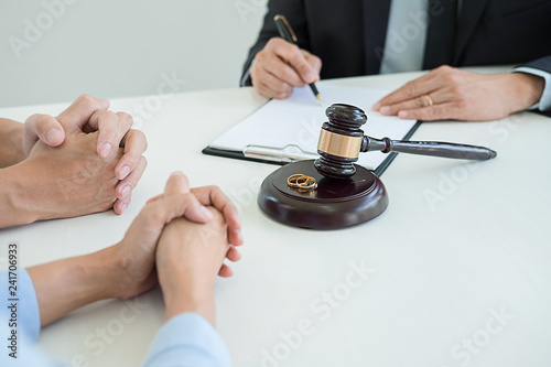 Judge gavel with Justice lawyers deciding, consultation on marriage divorce between married couple and signing divorce documents on table. Concepts of Law and Legal sevices.
