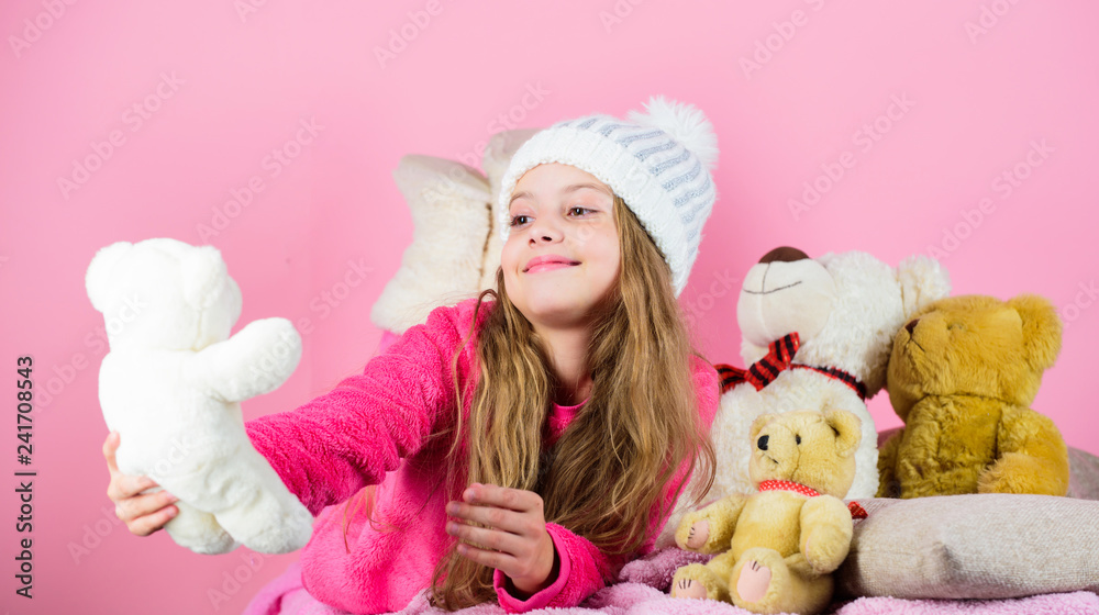 Fototapeta premium Child small girl playful hold teddy bear plush toy. Teddy bears help children handle emotions and limit stress. Kid little girl play with soft toy teddy bear on pink background. Bears toys collection