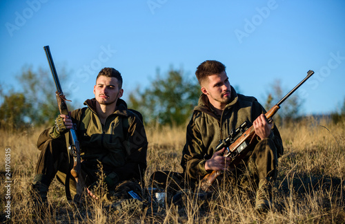 Hunting with friends hobby leisure. Rest for real men concept. Hunters gamekeepers relaxing. Discussing catch. Hunters with rifles relaxing in nature environment. Hunter friend enjoy leisure in field