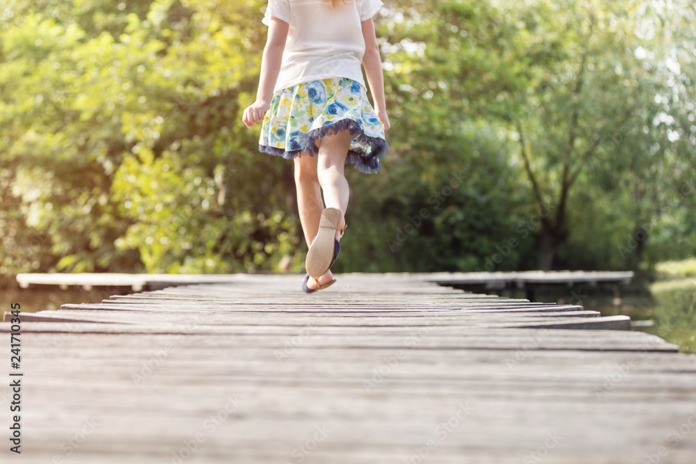 Low section of girl running on pier at lakeshore Low section of girl running on pier at lakeshore