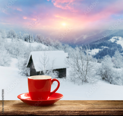 cup with a hot drink on the windowsill in the background of a winter city. Focus on the edge of the cup