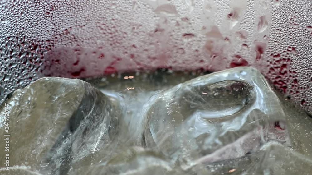 Abstract beauty in drink details. Extreme close-up of iced plum juice soda drink in glass. Water drops on the glass surface creates beautiful texture patterns. Abstract beauty in drink details. Extreme close-up of iced plum juice soda drink in glass. Water drops on the glass surface creates beautiful texture patterns.