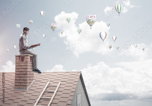 Handsome student guy reading book and aerostats flying in air © adam121