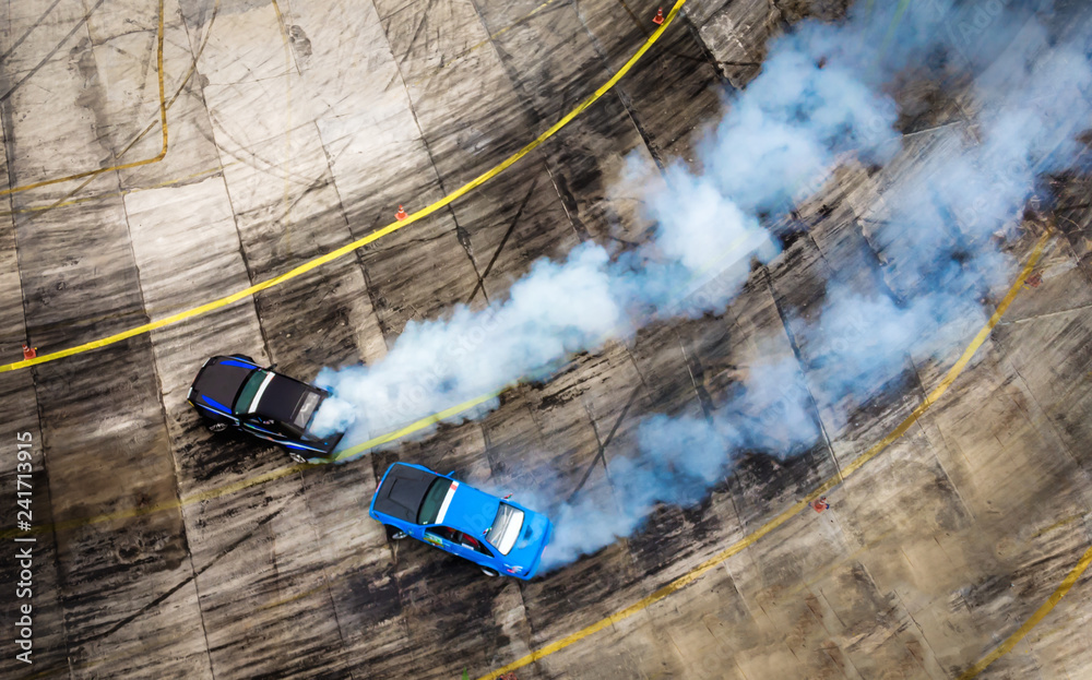 Aerial view from drone. Sport car wheel battle drifting. Blurred of image  diffusion race battle drift car with lots of smoke from burning tires on speed  track. Photos | Adobe Stock