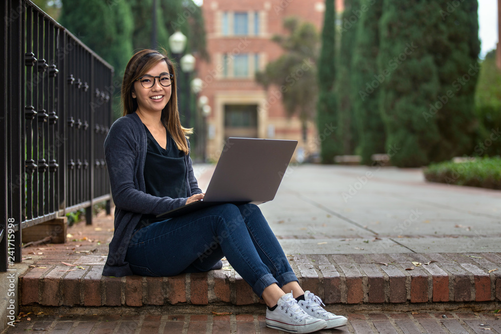 Teenager on laptop outdoors in urban park, wireless network internet Teenager on laptop outdoors in urban park, wireless network internet