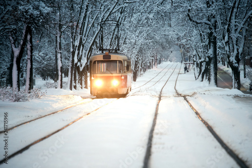 Evening tram rides through the snowy city.