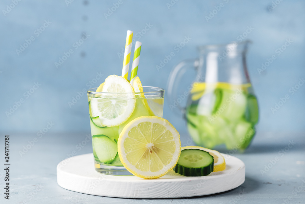 Fototapeta premium Detox Water with Cucumber and Lemon Summer Drink in Glass Jars on Blue Concrete Background Horizontal