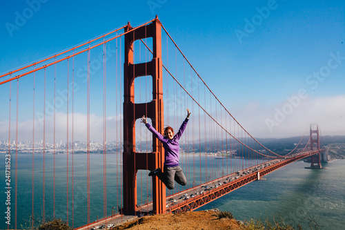 Woman jumping in front of the Golden Gate