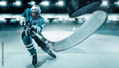 Ice Hockey player athlete in the helmet and gloves on stadium with stick. Action shot. Sport concept. photo