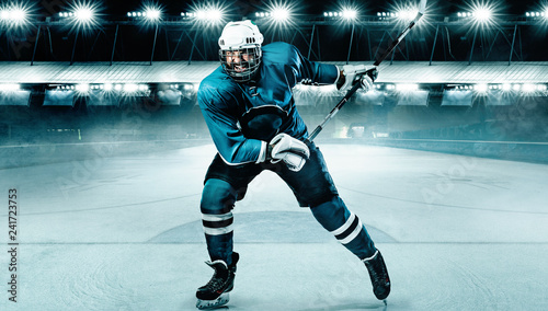 Ice Hockey player athlete in the helmet and gloves on stadium with stick. Action shot. Sport concept.
