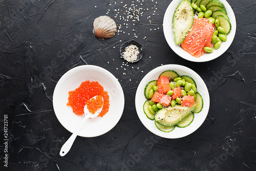 Fresh seafood recipe. Salmon and Caviar poke bowl with fresh prawn, brown rice, cucumber, pickled sweet onion, radish, soy beans edamame portioned with black and white sesame. Food concept poke bowl