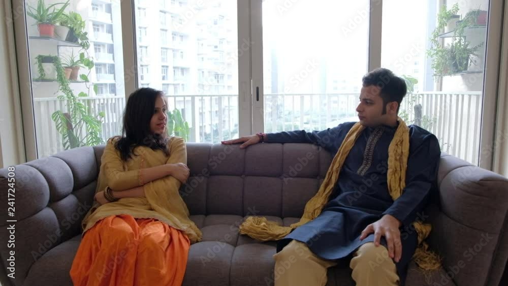 Indian man and woman in traditional Indian dresses sit apart and have a ...