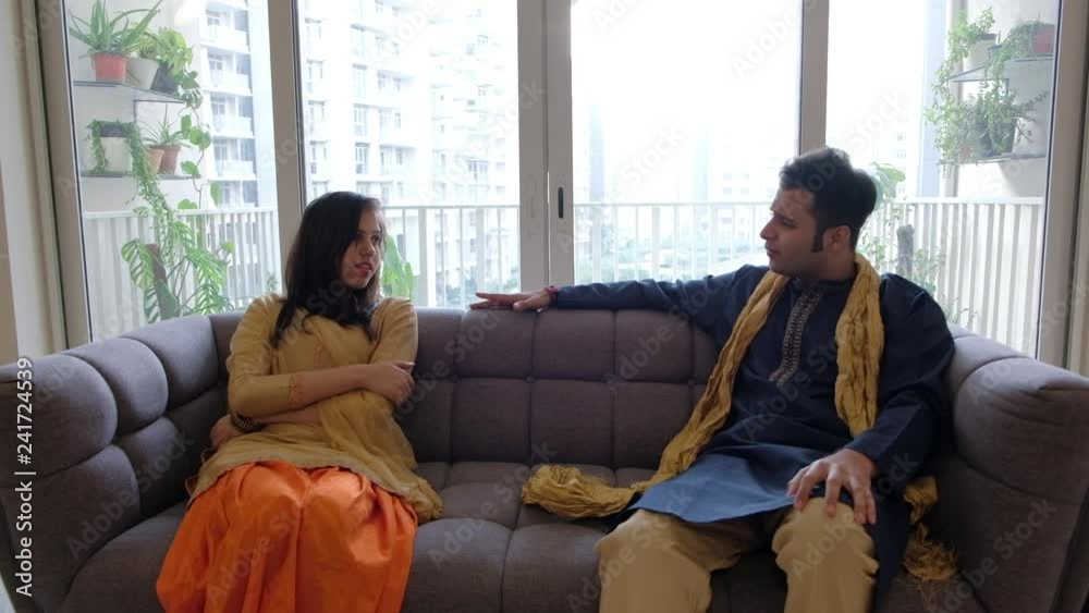 Indian man and woman in traditional Indian dresses sit apart and have a ...