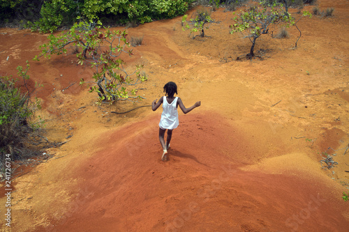 NOSY SAKATIA ISLAND, MADAGASCAR - OCTOBER 16,2018: Malagasy girl runs down the dunes among the rainforest
