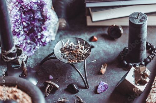 Foto Smoked herbs on a witch's altar for a magical ritual among crystals and black candles