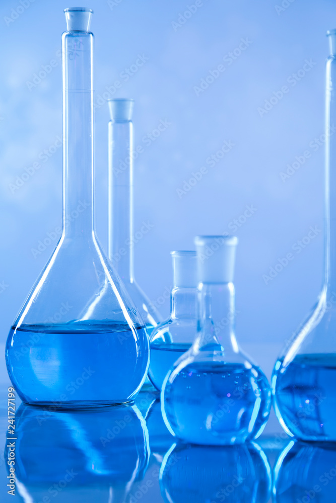 Laboratory beakers, microscope, blue background Laboratory beakers, microscope, blue background