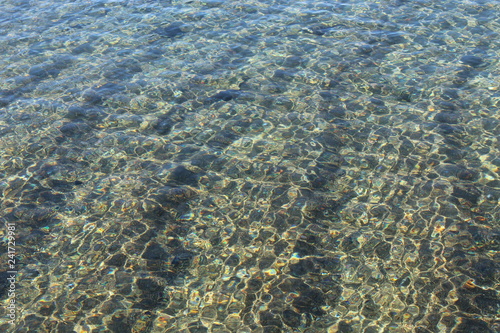 mare calmo trasparente con sabbia visibile