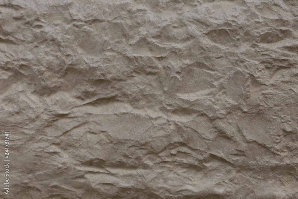 Beige stone surface with deep relief.