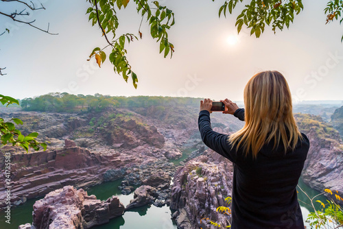 Woman take pictures in Gharial Sanctuary, India. Back view photo