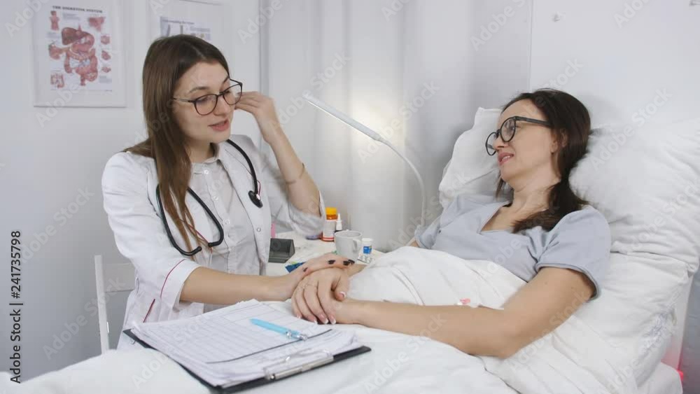 Doctor in hospital room talking with a woman patient and assigns the pills. Doctor in hospital room talking with a woman patient and assigns the pills.