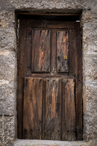 old brown wooden exterior door of a house with its rusty lock
