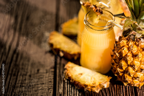 Pineapple juice and slice placed on a wooden table photo