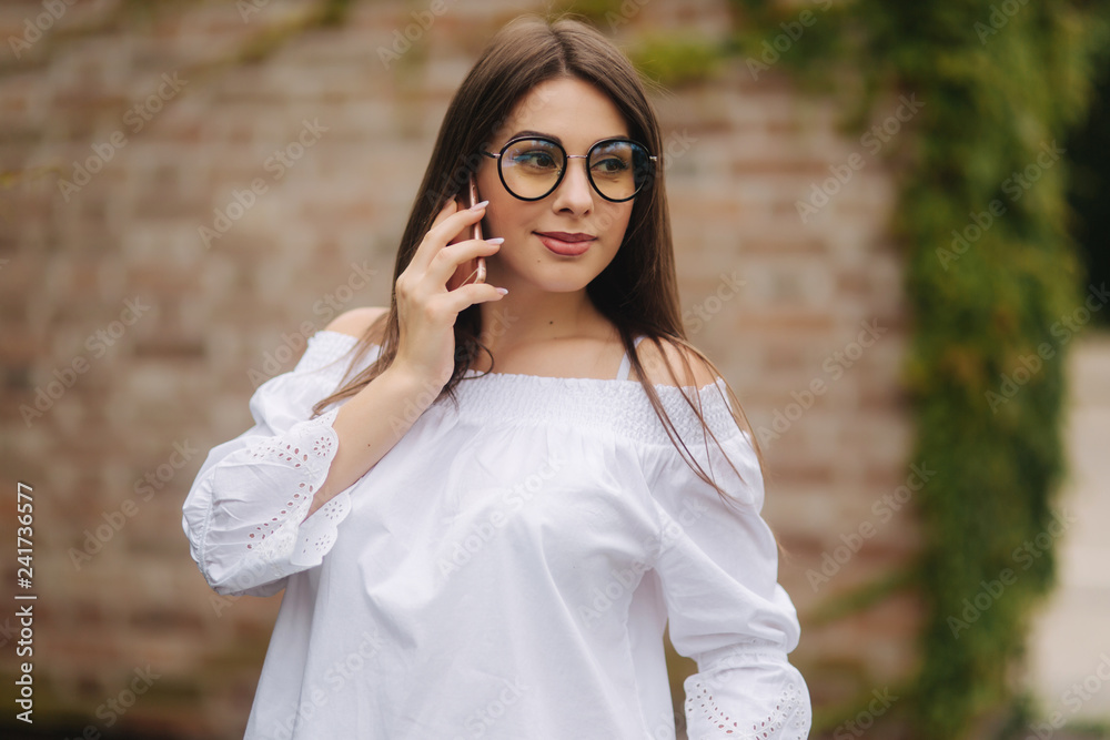 Young cheerful woman watching funny video on smart phone while resting outdoors Young cheerful woman watching funny video on smart phone while resting outdoors