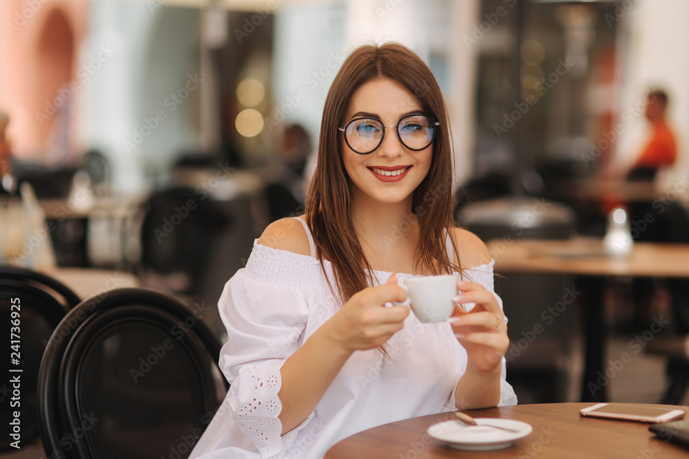 Close up fashion image of woman holding white cup of her morning cappuccino, wearing white stylish clothes and vintage sunglasses. Enjoy her time alone. Instagram colors Close up fashion image of woman holding white cup of her morning cappuccino, wearing white stylish clothes and vintage sunglasses. Enjoy her time alone. Instagram colors