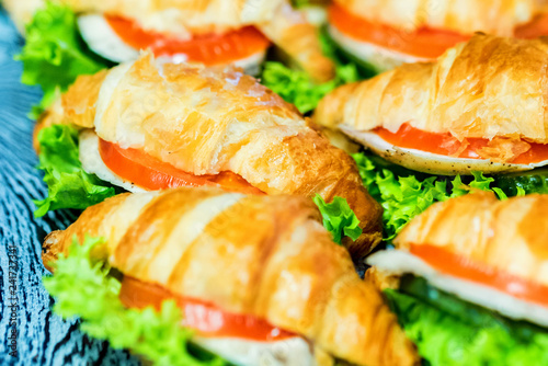 Close up fresh croissants with salad, ham and cheese on table