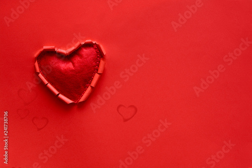 Ripped paper hole heart shaped with felt heart on red paper background. Valentine s day celebration concept