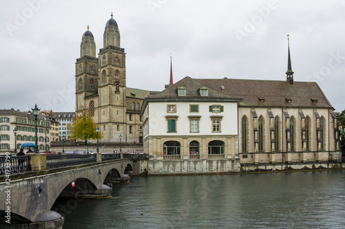 ZURICH, SWITZERLAND - OCT 130th, 2018: View of Grossmunster and Zurich old town from Limmat river. The Grossmunster is a Romanesque Protestant church in Zurich, Switzerland. Rainy weather in autumn.