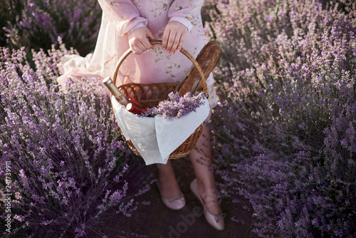Fototapeta Naklejka Na Ścianę i Meble -  woman holds wicker basket and looks for good place for picnic