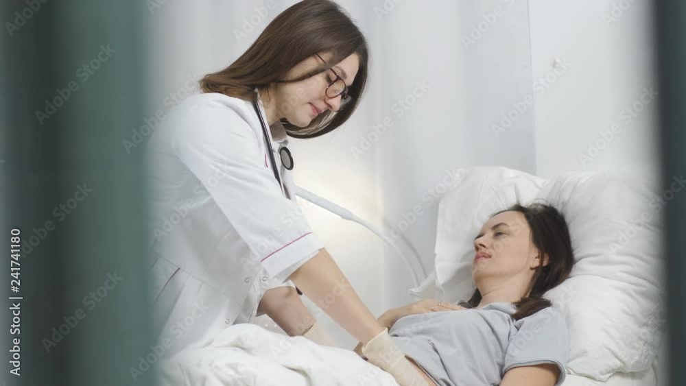 Woman doctor with gloves palpated the abdomen of the patient in the hospital. Woman doctor with gloves palpated the abdomen of the patient in the hospital.