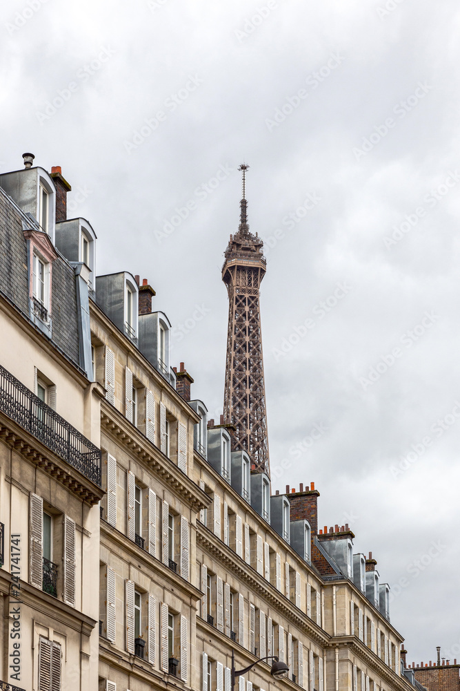 view of the eiffel tower through the roofs of houses