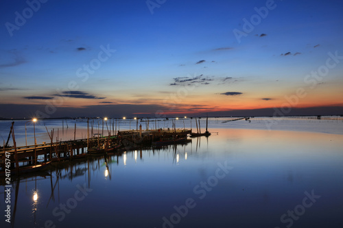 landscape or nature view of old fisherman bridge over to sea with blue sky during twilight time in Chonburi Province, Thailand