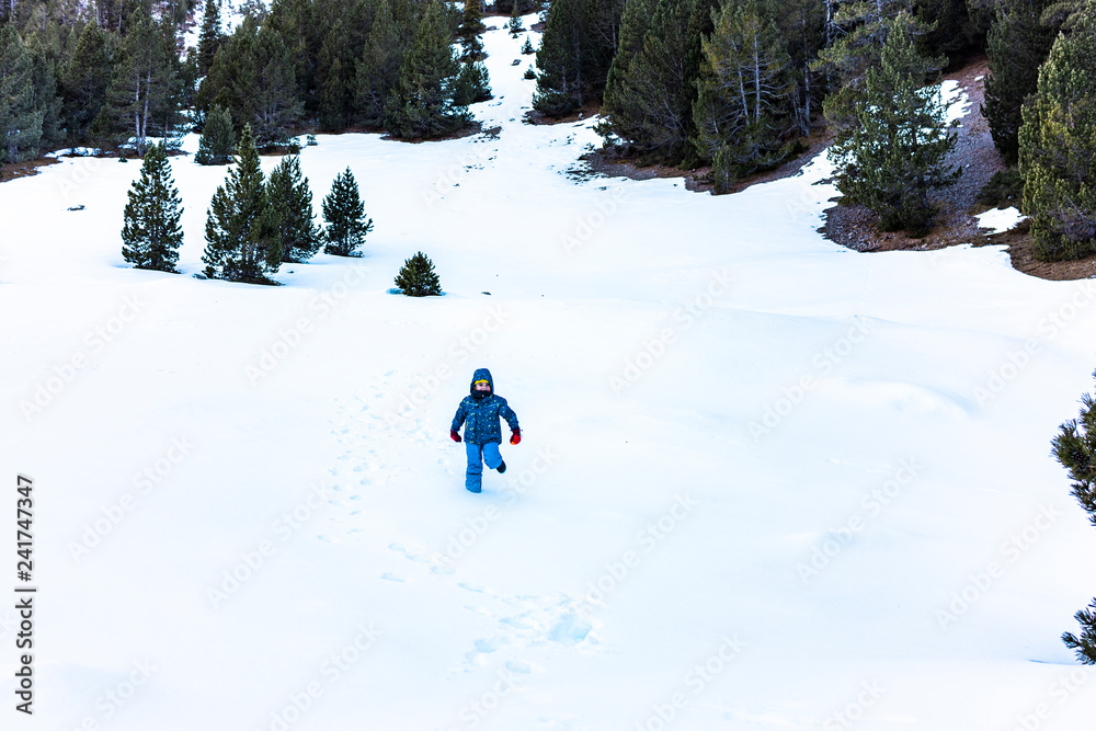 Boy running down a snowy mountain