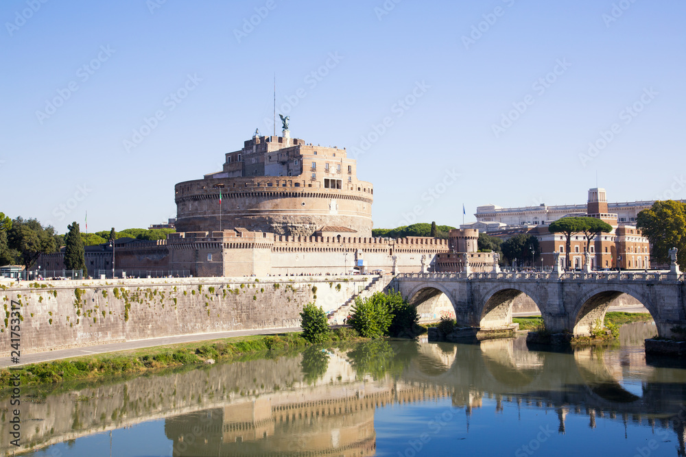 View on the famous Castel Sant Angelo and the bridge over the Tiber river in Rome, Italy. Set in soft afternoon sunlight and shot against a clear blue sky.
