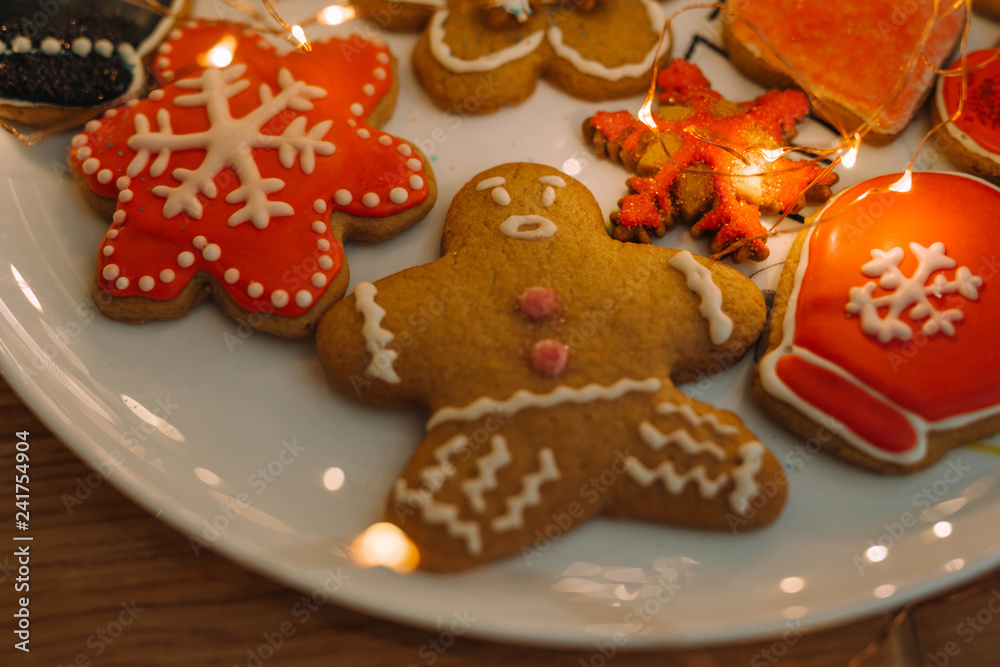 Gingerbread cookies on white dish with golden lights.