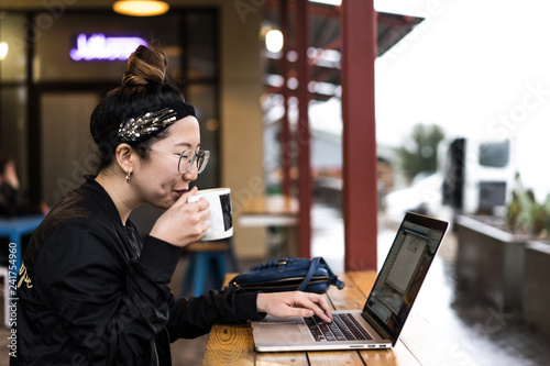 Young woman working on laptop in cafe