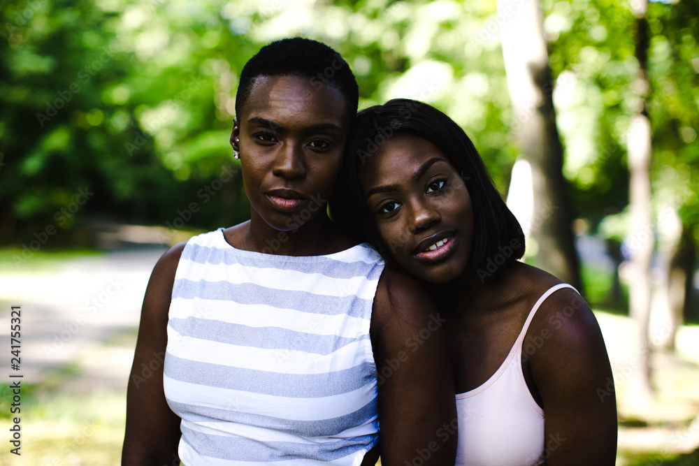 Portrait of lesbian couple standing outdoors Portrait of lesbian couple standing outdoors