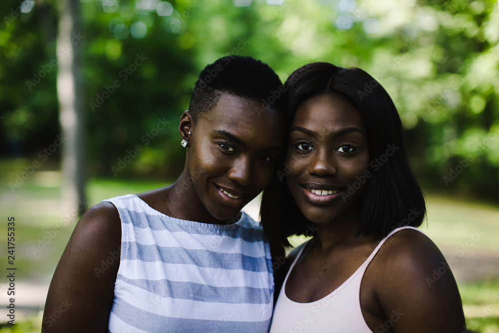 Portrait of smiling lesbian couple standing outdoors Portrait of smiling lesbian couple standing outdoors
