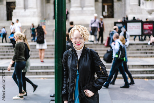 Woman leaning against pole on street