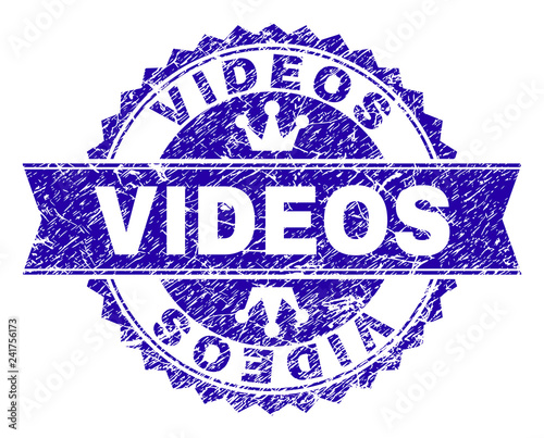 VIDEOS rosette stamp seal imprint with distress texture. Designed with round rosette, ribbon and small crowns. Blue vector rubber print of VIDEOS text with dust texture.